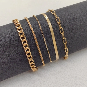 Detail of 5-piece gold chain bracelet set with cuban, snake, and paperclip styles