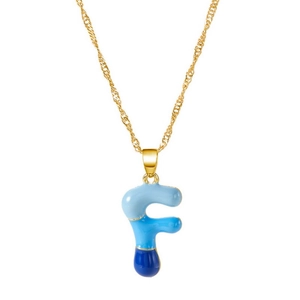 Dettaglio catena dorata con pendente a lettera F in smalto blu sfumato