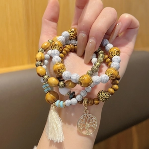 Détail du bracelet bohème multicouche en perles de bois avec pendentif arbre de vie et gland