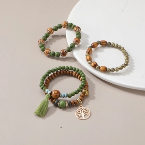 Détail du lot de bracelets bohèmes en bois avec pendentif arbre de vie et gland vert