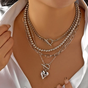 Layered silver chain necklace featuring paperclip links, OT buckle, and a heart pendant