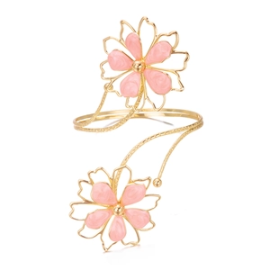 Vue détaillée d'un bracelet de bras doré avec d'élégantes fleurs de lotus en émail rose et métal