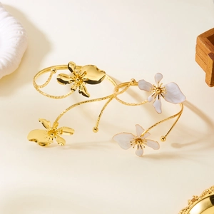 Bracelet jonc ouvert et bague lotus dorés avec détails floraux en émail blanc