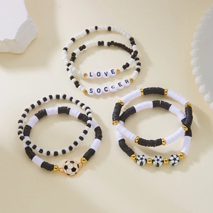 Detail of soccer themed bracelets with black and white heishi beads and gold accents