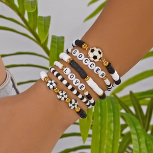 Close-up of multilayer soccer bracelets with Heishi beads and metal accents on wrist