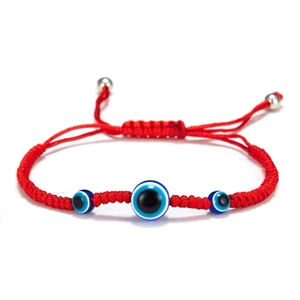 Detail of red braided Evil Eye bracelet featuring blue glass beads and adjustable cord