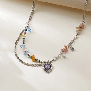 Close-up of bohemian multi-layered necklace featuring blue rhinestones and heart pendant