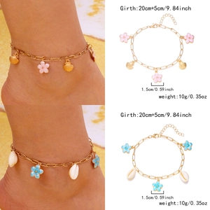 Detail of beach anklets with pink and blue enamel flowers and natural sea shell pendants