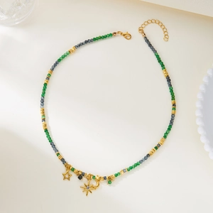 Detail of beaded star and moon necklace with green beads and gold charms