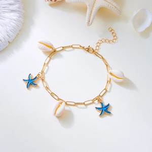 Detail of bohemian gold seashell and blue starfish charms on a beach style anklet
