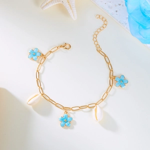 Detail of bohemian gold beach anklet with blue flower charms and white seashells