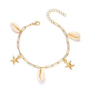 Close-up of golden anklet featuring natural white shells and starfish charms in detail