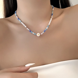 Close-up of blue rhinestone butterfly layered necklace on model's neck for summer style