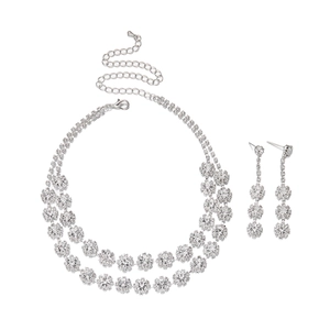 Dettaglio di collana a doppio strato argentata e orecchini floreali con strass brillanti