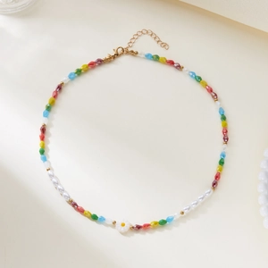 Close-up of colorful beaded necklace with small white daisy charm and gold clasp
