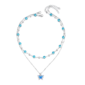 Detailed view of silver double-layered necklace with blue butterfly pendant and zircon stones