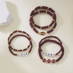 Macro view of burgundy clay beads and rugby theme charms with LOVE lettering