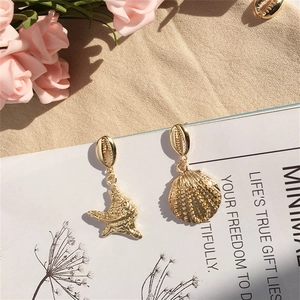 Pendientes bohemios de estrella de mar y concha dorados con diseño asimétrico de playa