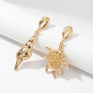 Detalle de pendientes asimétricos bañados en oro con diseño de estrella de mar y caracol