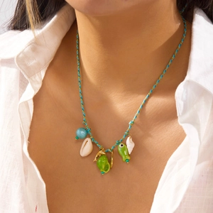 Detail of woven beach necklace with shell pendants and starfish charms on female model
