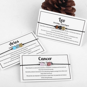 Handmade zodiac constellation beaded bracelets with white description cards on white texture