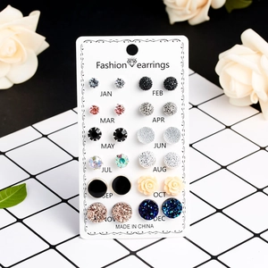 Detailansicht eines 12-Paar-Ohrring-Sets mit Kristallsteckern und Blumen auf einer Karte
