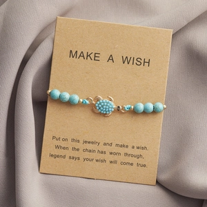 Bracciale di perle turchesi con tartaruga blu su scheda regalo in carta kraft