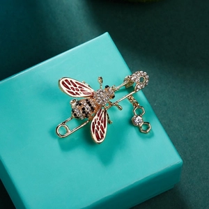Broche abeille dorée avec ailes en émail rouge, strass et pendentif en nid d'abeille