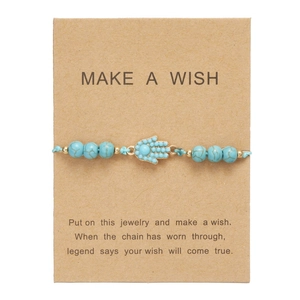 Dettaglio bracciale con perline turchesi e mano di hamsa su cartoncino Make a Wish