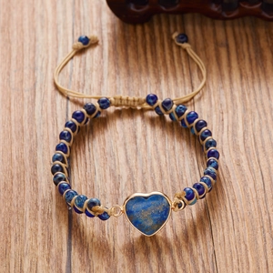 Detail of handmade heart charm bracelet with blue lapis beads and adjustable woven cord