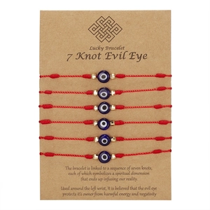 Set van 6 rode gevlochten 7-knoop armbanden met blauwe evil eye kralen op een kaart
