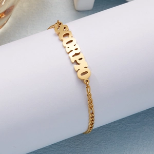 Detailed shot of gold Scorpio charm bracelet with Figaro chain and lobster clasp