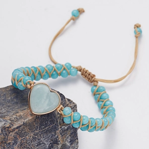 Close-up of handmade heart stone bracelet with blue beads and woven cord detail