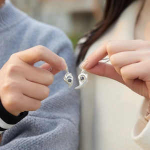Close-up of magnetic sun and moon heart necklaces with 100 languages projection stone