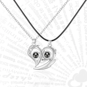Detail of magnetic heart pendants for couples featuring a projection stone and dual chains
