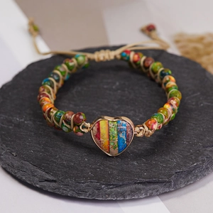 Vista macro de la pulsera bohemia tejida con piedra natural en corazón y cuentas de colores