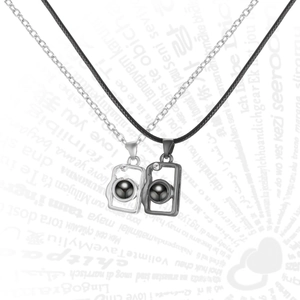 Detail of couple projection necklaces with Sun and Moon pendant on romantic text background