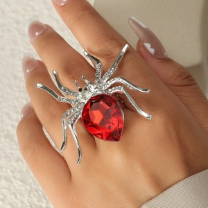 Dettaglio dell'anello a ragno con cristallo rosso e strass argentati sul dito
