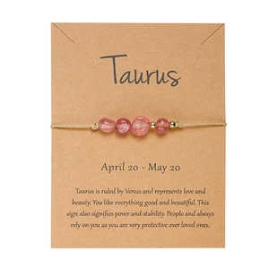 Dettaglio del bracciale zodiacale Toro con perle di quarzo rosa su carta kraft