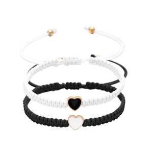 Dettaglio di braccialetti intrecciati con pendenti a cuore in smalto bianco e nero