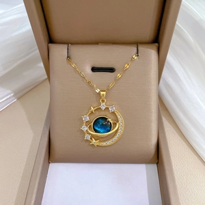 Detail of gold star and moon necklace featuring a deep blue planetary resin pendant