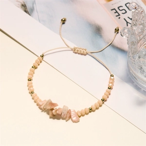 Adjustable beige woven bracelet featuring light pink raw natural stones and gold beads