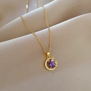 Elegant gold crescent moon necklace with purple teardrop gemstone and sparkling star accents