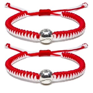Dettaglio di due braccialetti da baseball intrecciati rossi e bianchi con perla in argento