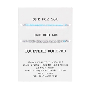Dettaglio di braccialetti in perline luminose su carta con scritta Together Forever