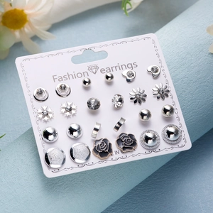 Detailed set of 12 pairs of silver-colored earrings with rhinestones on white card