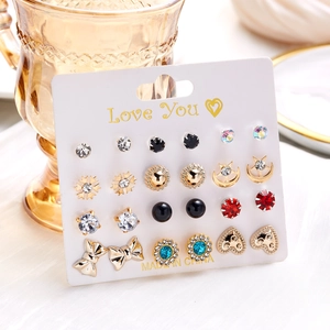 Close-up of 12-pair gold earring set with colorful rhinestones on a Love You card