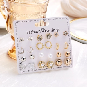 Detail shot of a 12-pair floral and heart stud earring set on a display card