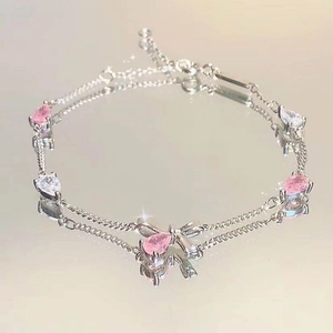 Elegante pulsera plateada con piedras rosas en forma de pera y un dije de lazo joya