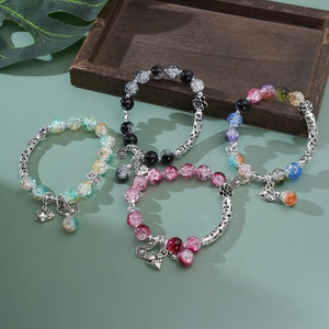 Detailed macro of 925 sterling silver cat and flower charms on beaded crystal bracelets